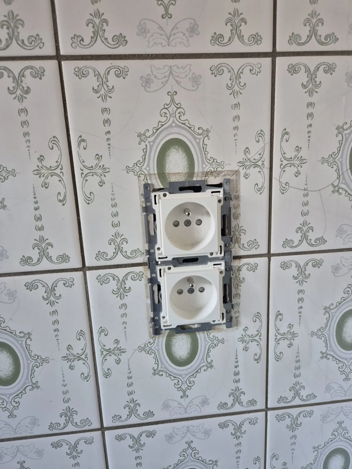 Deux prises encastrées dans le carrelage, avant la plaque.