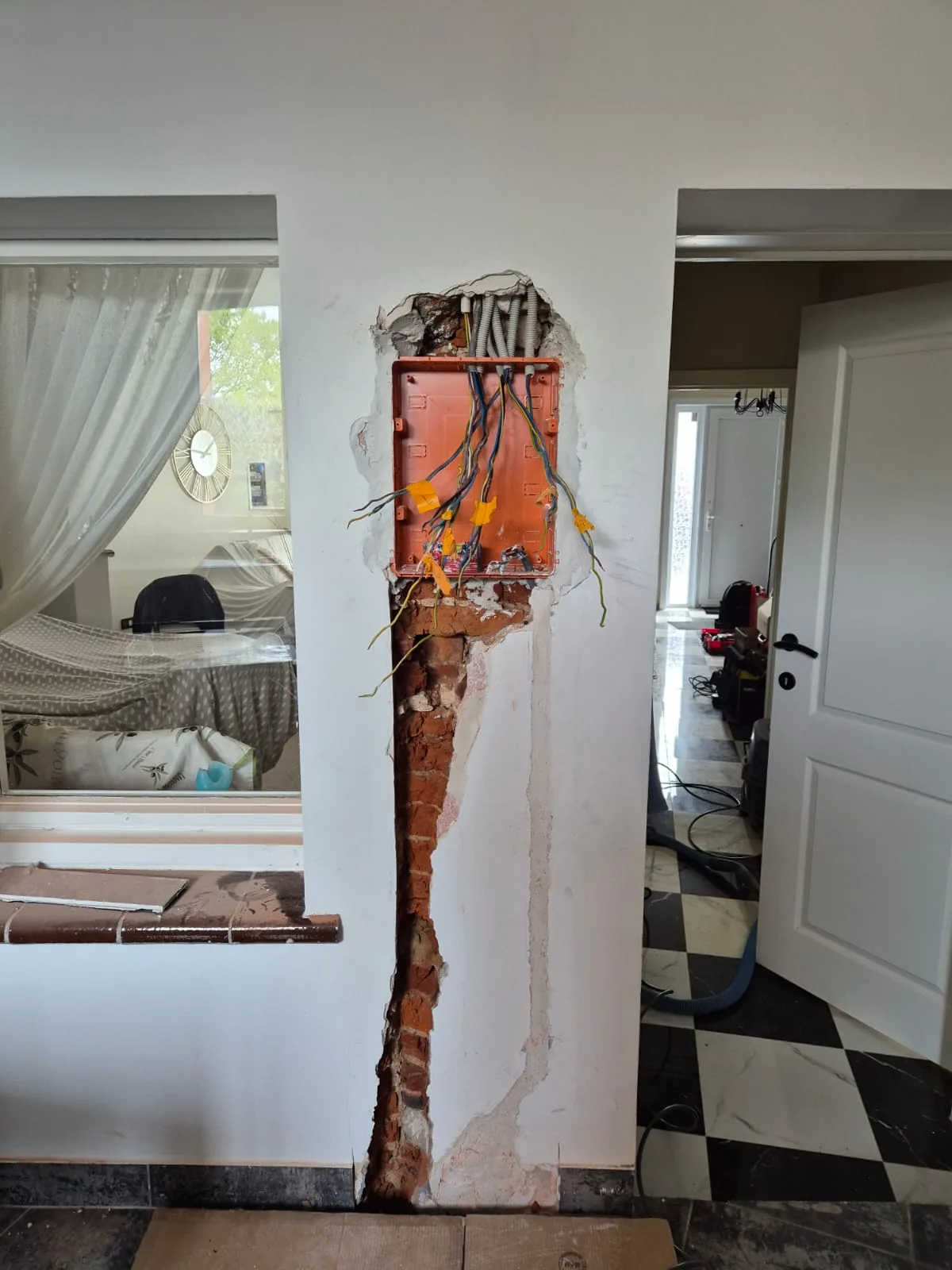 Nouveau coffret encastré dans un couloir, chantier en cours dans un logement habité.