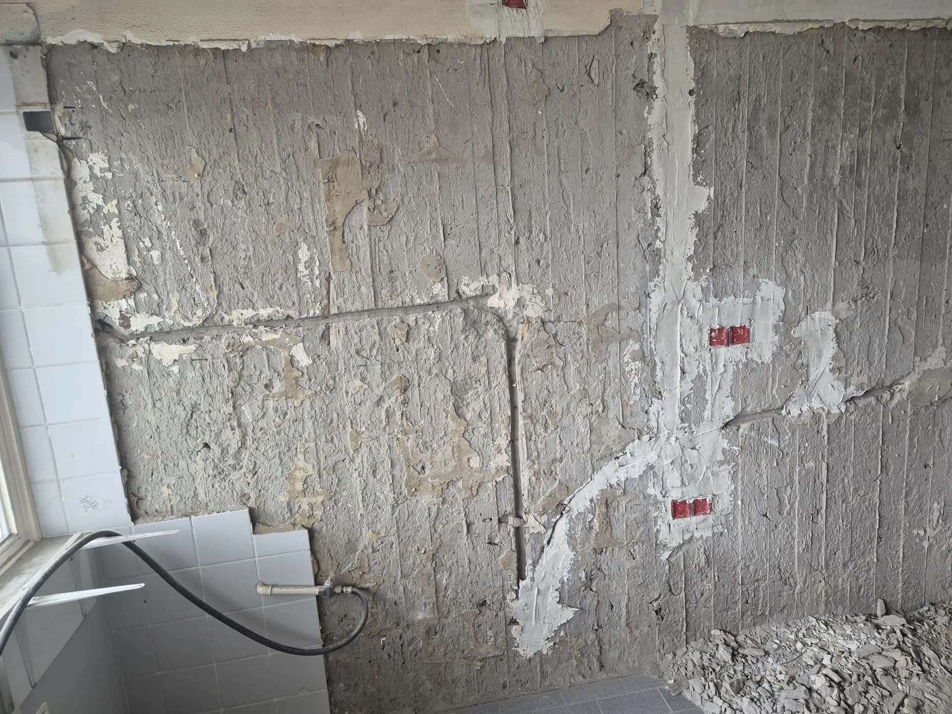 Cuisine en rénovation : mur décapé, saignées et boîtiers posés pour les nouveaux circuits.