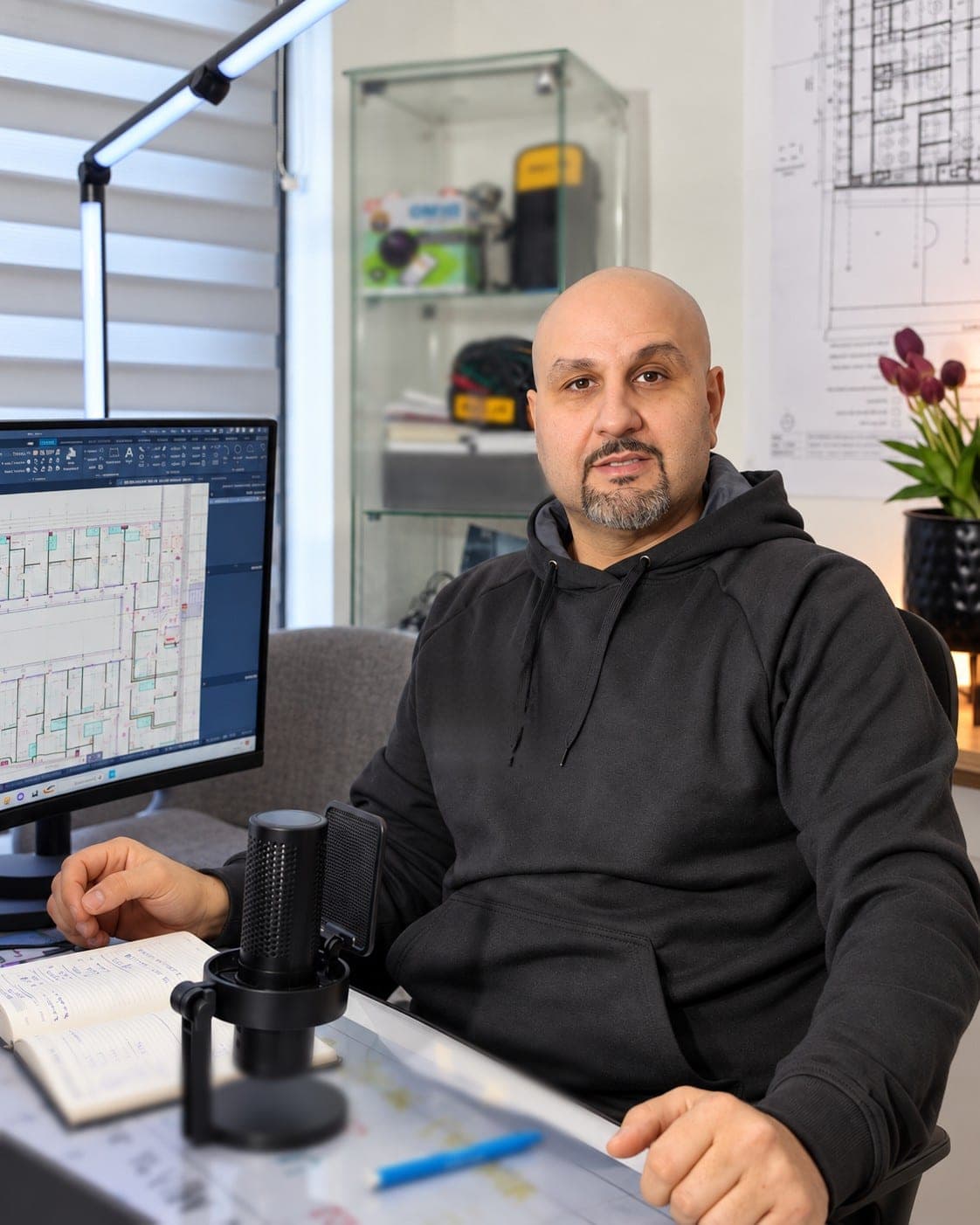 Ismaël, co-fondateur de Belix Group, à son bureau d'étude devant un plan électrique